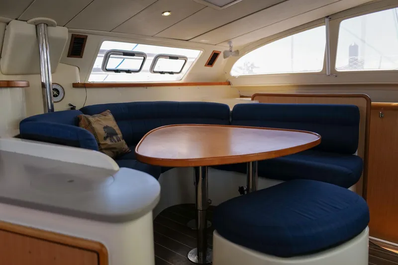 Slide: The Image of Interior of a 2006 Leopard 43 yacht with a cozy dining area and blue seating. - 39