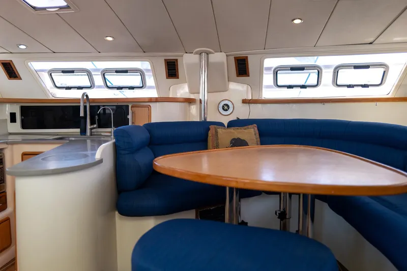 Slide: The Image of Interior of 2006 Leopard 43 yacht with blue seating and wooden table. - 40