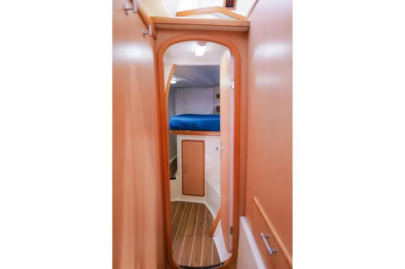 Slide: The Image of Interior cabin view of a 2006 Leopard 43 yacht with wooden finishes and blue bedding. - 49