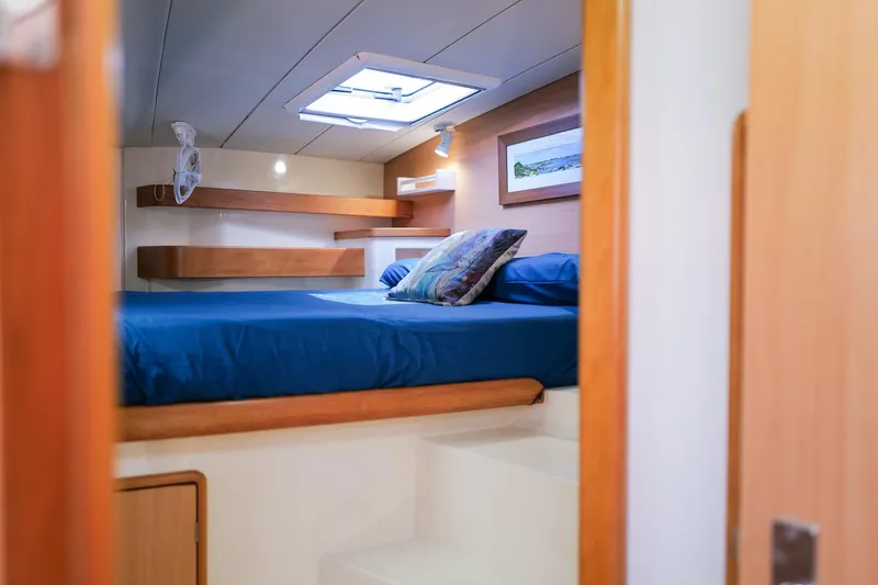 Slide: The Image of Cozy cabin interior of 2006 Leopard 43 yacht with blue bedding and wooden accents. - 50
