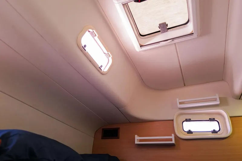 Slide: The Image of Interior cabin view of a 2006 Leopard 43 yacht, featuring windows and storage shelves. - 52