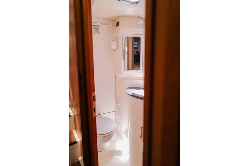 Slide: The Image of Compact bathroom interior on a 2006 Leopard 43 yacht, featuring a toilet and mirror. - 58