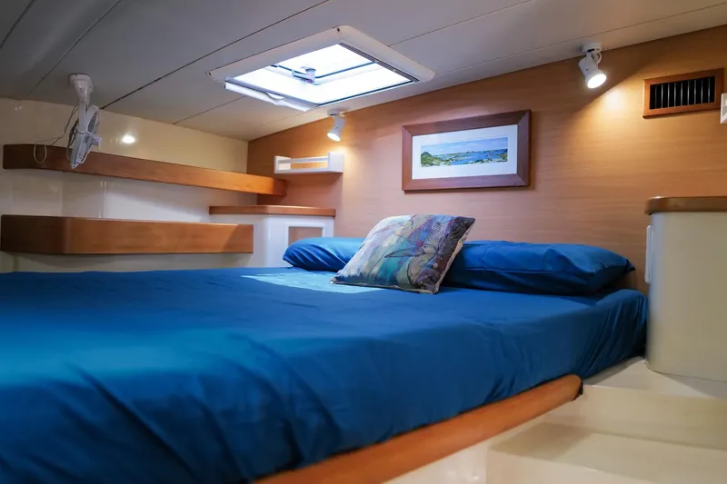 Slide: The Image of Luxurious cabin interior of a 2006 Leopard 43 yacht with blue bedding and modern decor. - 59
