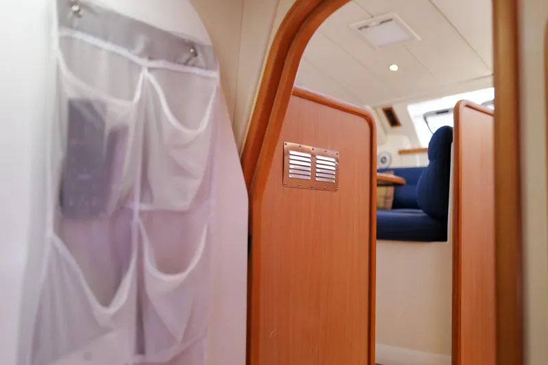 Slide: The Image of Interior of a 2006 Leopard 43 yacht, featuring wooden paneling and seating area. - 62