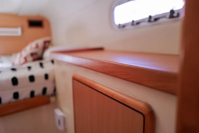 Slide: The Image of Interior of 2006 Leopard 43 yacht cabin with wooden finish and patterned bedding. - 66