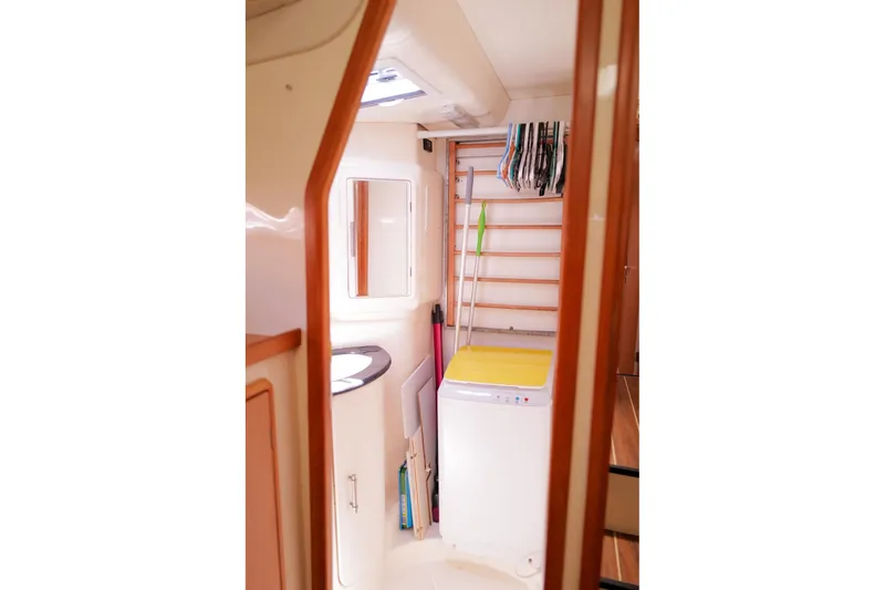 Slide: The Image of Laundry area inside a 2006 Leopard 43 yacht, featuring a washing machine and storage space. - 69