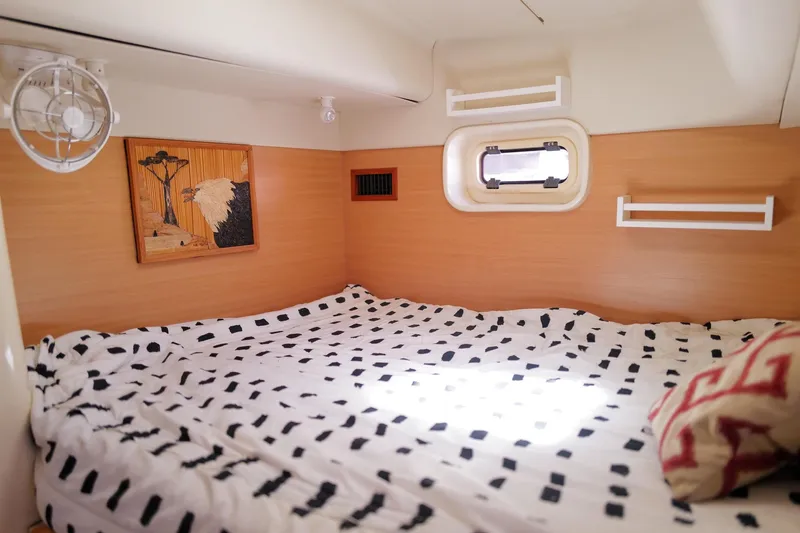 Slide: The Image of Cozy cabin interior of a 2006 Leopard 43 yacht with patterned bedding and wall art. - 75