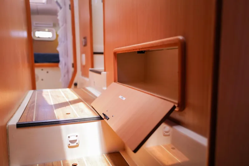 Slide: The Image of Interior of a 2006 Leopard 43 yacht, featuring wooden cabinetry and storage compartments. - 77