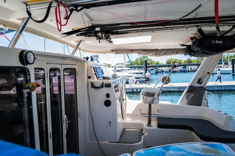 Slide: The Image of Interior view of a 2006 Leopard 43 catamaran at a marina, showcasing helm and seating area. - 9