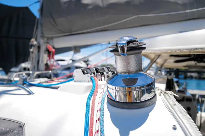 Slide: The Image of Close-up of a winch on a 2006 Leopard 43 sailboat, with colorful ropes and clear sky. - 94