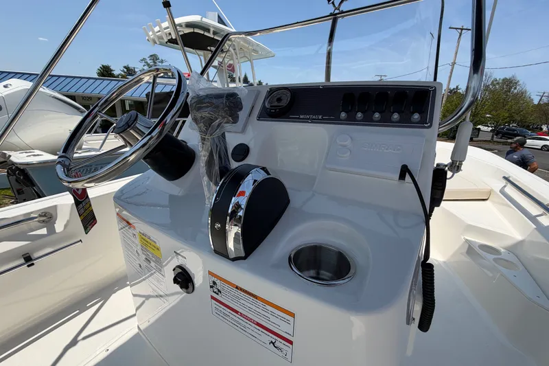 Slide: The Image of The image shows the helm of a Boston Whaler 170 Montauk with steering wheel and instruments. - 7