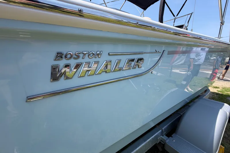 Slide: The Image of Close-up of the Boston Whaler 170 Montauk with a shiny logo on the side. - 13