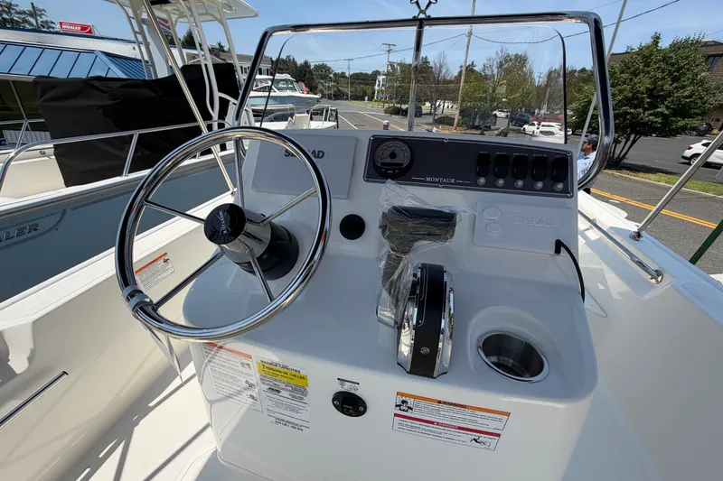 Slide: The Image of The image shows the helm of a 2027 Boston Whaler 170 Montauk with a steering wheel and instruments. - 8