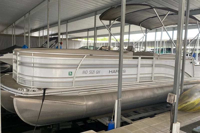 The Image of 2018 Harris Solstice 240 pontoon boat docked under a covered marina. - 1