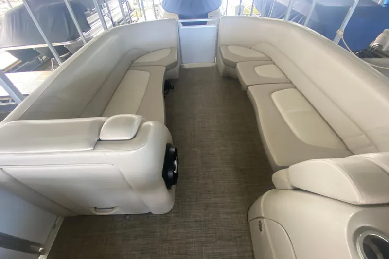 Slide: The Image of Interior seating of a 2018 Harris Solstice 240 pontoon boat, featuring beige upholstery. - 17