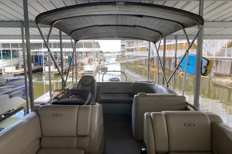 Slide: The Image of 2018 Harris Solstice 240 pontoon boat docked under covered marina. - 18