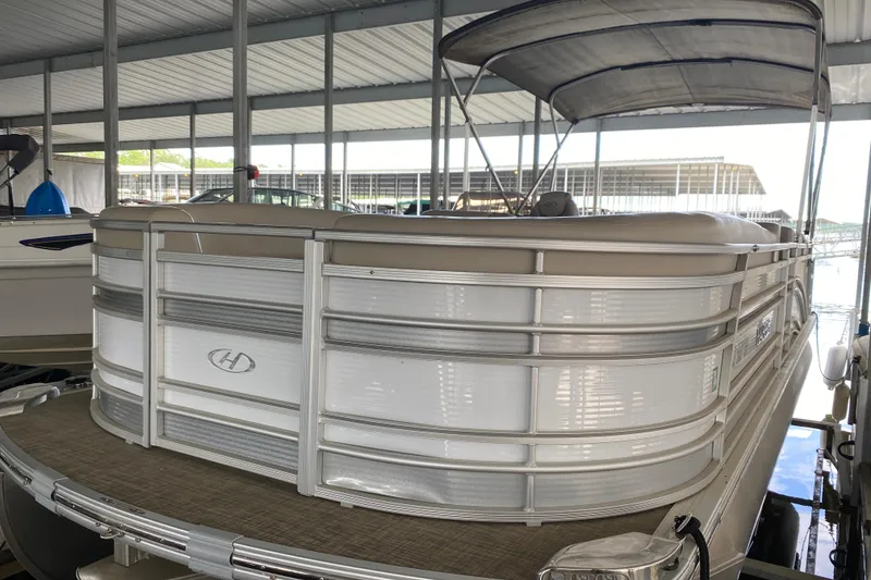 Slide: The Image of 2018 Harris Solstice 240 pontoon boat docked under a covered marina. - 2