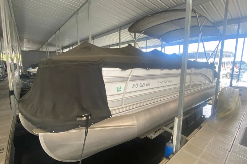 Slide: The Image of 2018 Harris Solstice 240 pontoon boat docked with cover in marina. - 26