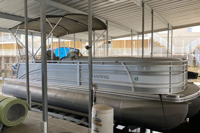 Slide: The Image of 2018 Harris Solstice 240 pontoon boat docked under a covered marina. - 3