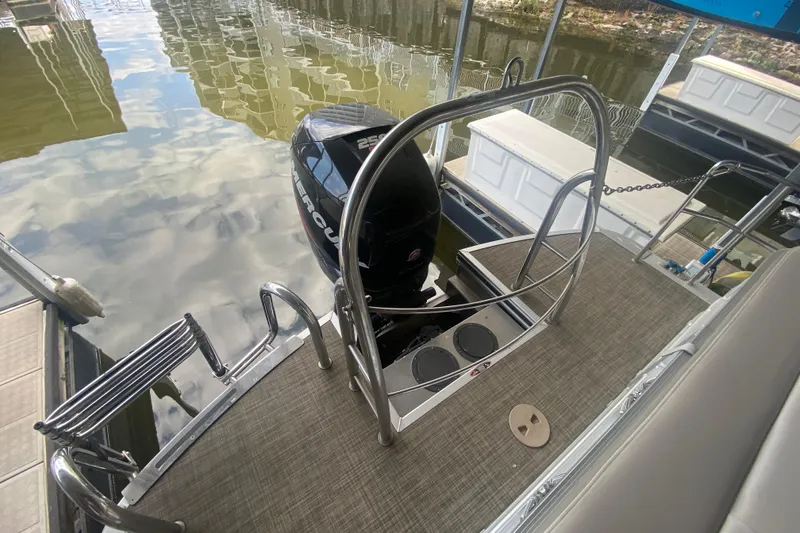 Slide: The Image of 2018 Harris Solstice 240 boat with Mercury outboard motor, docked on calm water. - 5