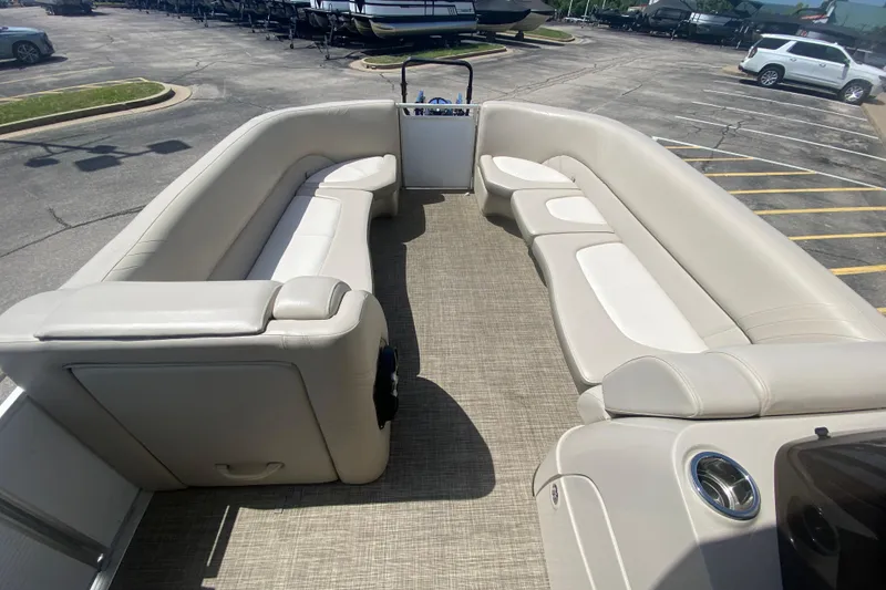 Slide: The Image of 2018 Harris Solstice 240 pontoon boat interior with spacious seating in a parking lot. - 11