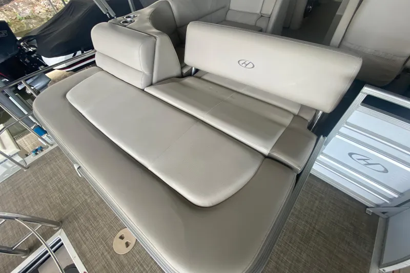 Slide: The Image of 2018 Harris Solstice 240 boat interior with beige seating and cup holders. - 7