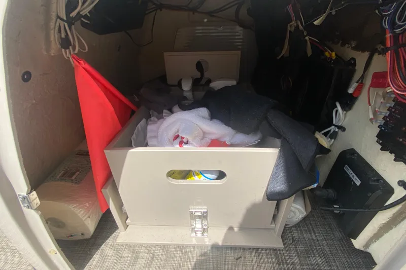 Slide: The Image of Storage compartment of a 2018 Harris Solstice 240 boat, featuring organized equipment and supplies. - 13