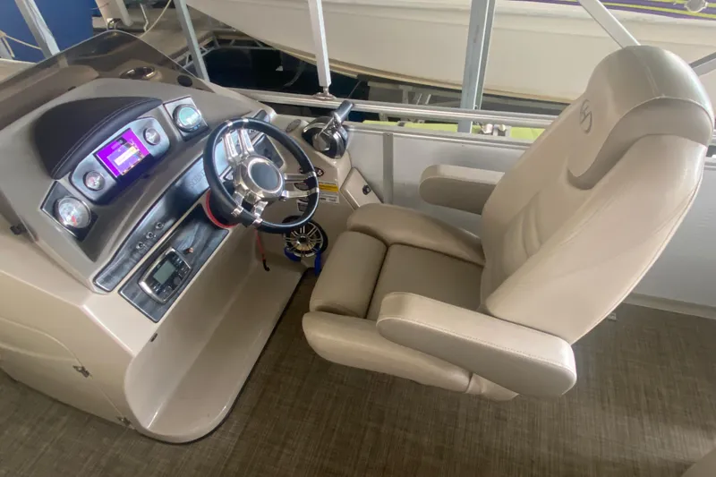 Slide: The Image of Captain's chair and dashboard of a 2018 Harris Solstice 240 boat, featuring modern controls. - 9