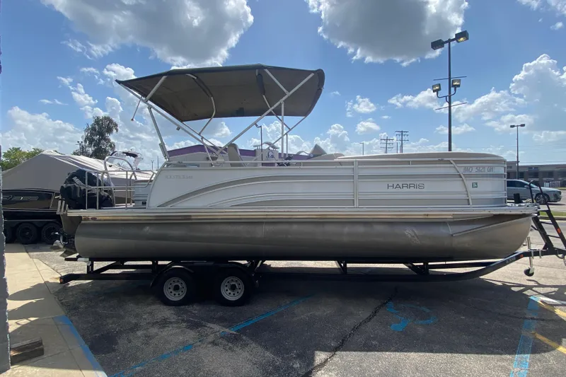 Slide: The Image of 2018 Harris Solstice 240 pontoon boat on trailer under a sunny sky. - 5