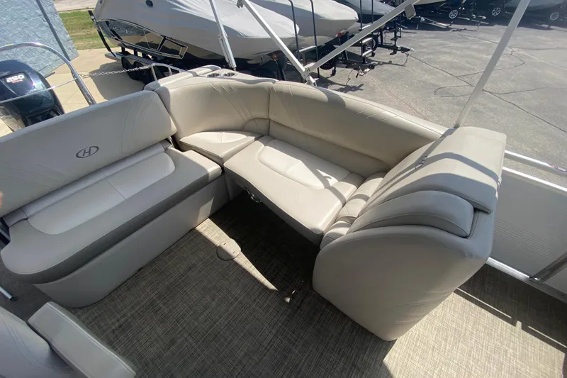 Slide: The Image of 2018 Harris Solstice 240 boat interior with beige seating and carpeted flooring. - 21