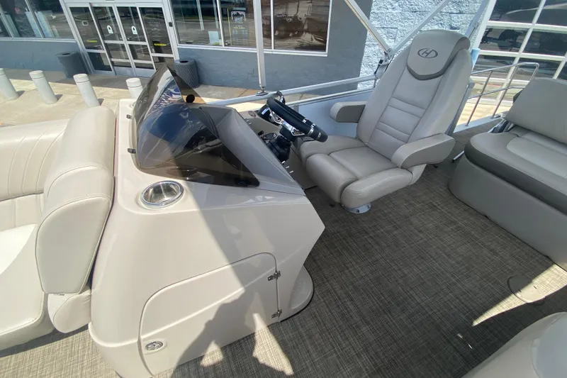 Slide: The Image of 2018 Harris Solstice 240 boat interior with helm, steering wheel, and comfortable seating. - 12