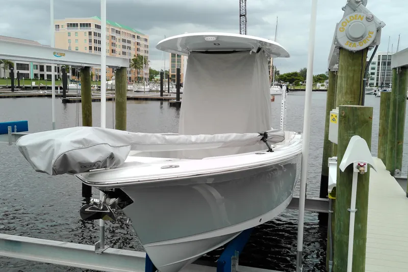 The Image of 2026 Sea Hunt Ultra 235 SE boat docked at a marina with protective cover. - 0
