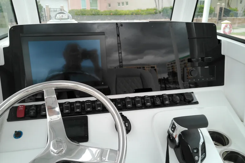 Slide: The Image of Steering console of 2026 Sea Hunt Ultra 235 SE boat with modern controls and display. - 11