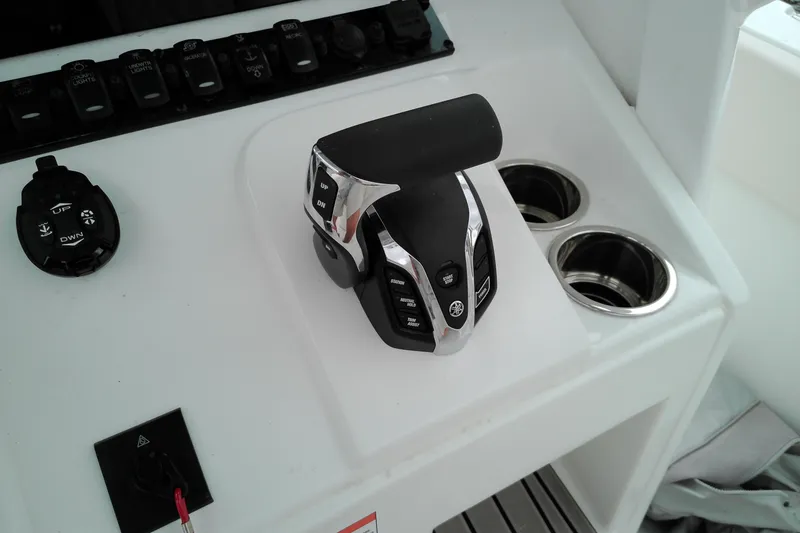 Slide: The Image of Control panel of 2026 Sea Hunt Ultra 235 SE boat with throttle and cup holders. - 15