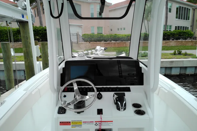 Slide: The Image of 2026 Sea Hunt Ultra 235 SE boat dashboard with steering wheel and controls. - 16