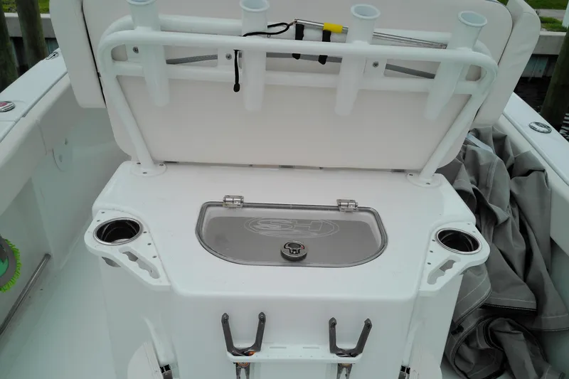Slide: The Image of 2026 Sea Hunt Ultra 235 SE boat interior with rod holders and storage compartment. - 25