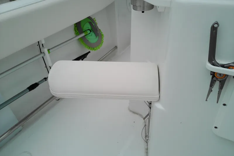 Slide: The Image of 2026 Sea Hunt Ultra 235 SE boat interior with white cushioned seat and fishing tools. - 26