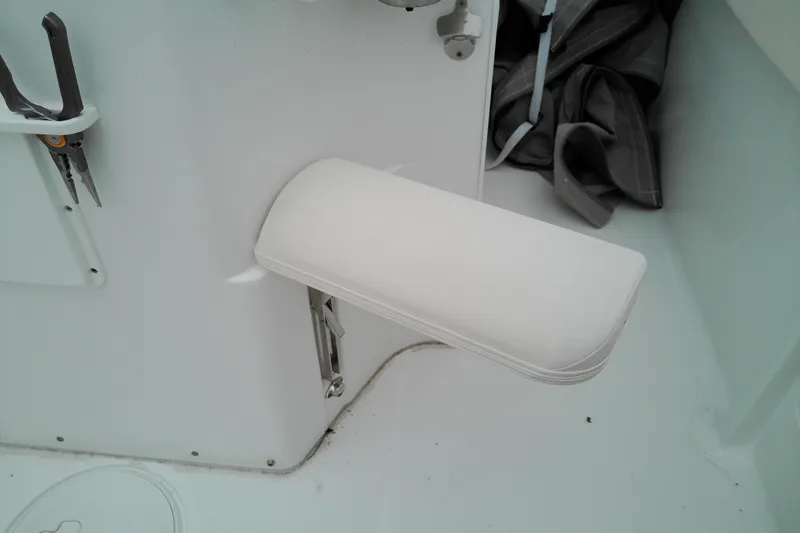 Slide: The Image of Foldable seat on 2026 Sea Hunt Ultra 235 SE boat, with white upholstery and nearby tools. - 27