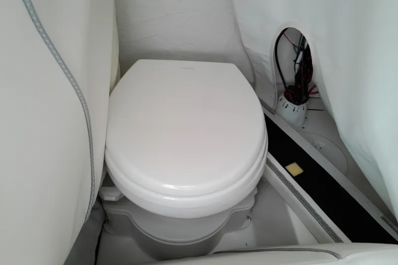 Slide: The Image of 2026 Sea Hunt Ultra 235 SE boat interior with compact marine toilet. - 32