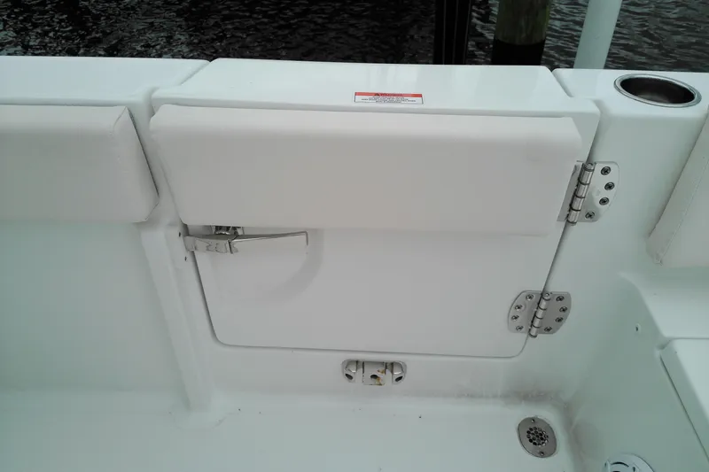 Slide: The Image of 2026 Sea Hunt Ultra 235 SE boat interior with white cushioned seating and storage compartment. - 33