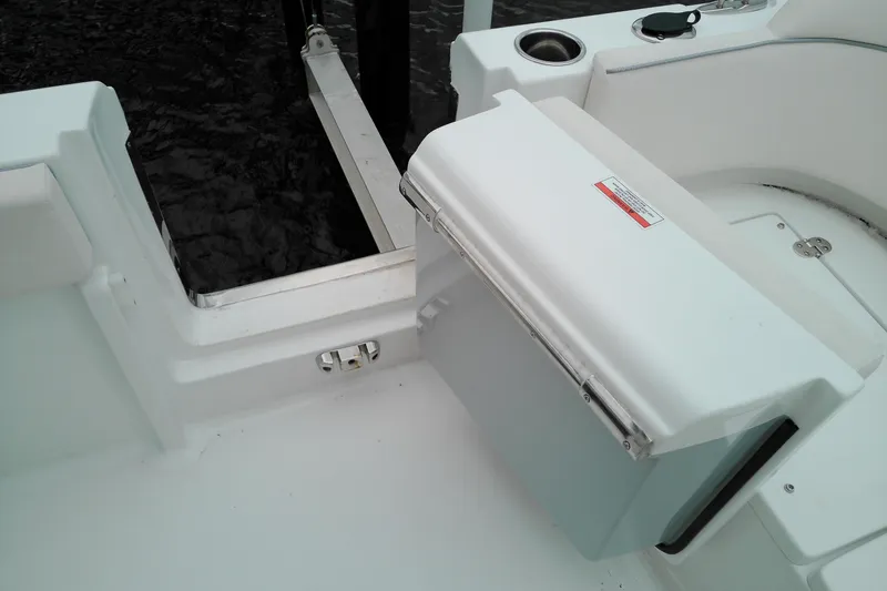 Slide: The Image of 2026 Sea Hunt Ultra 235 SE boat interior with storage compartment and cup holder. - 34
