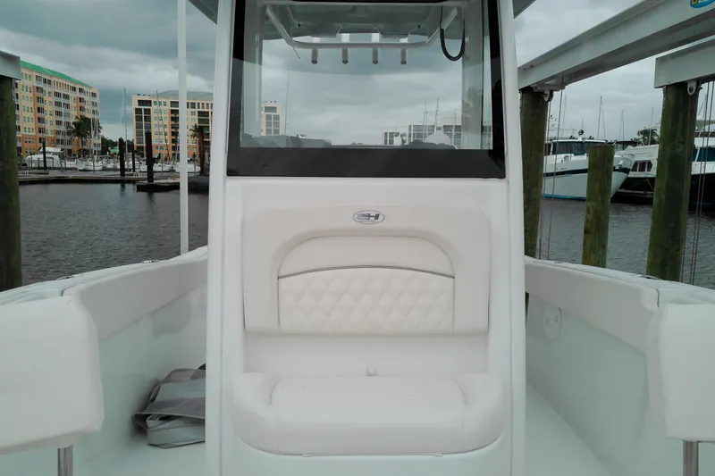 Slide: The Image of 2026 Sea Hunt Ultra 235 SE boat interior at marina, featuring white seating and modern design. - 8