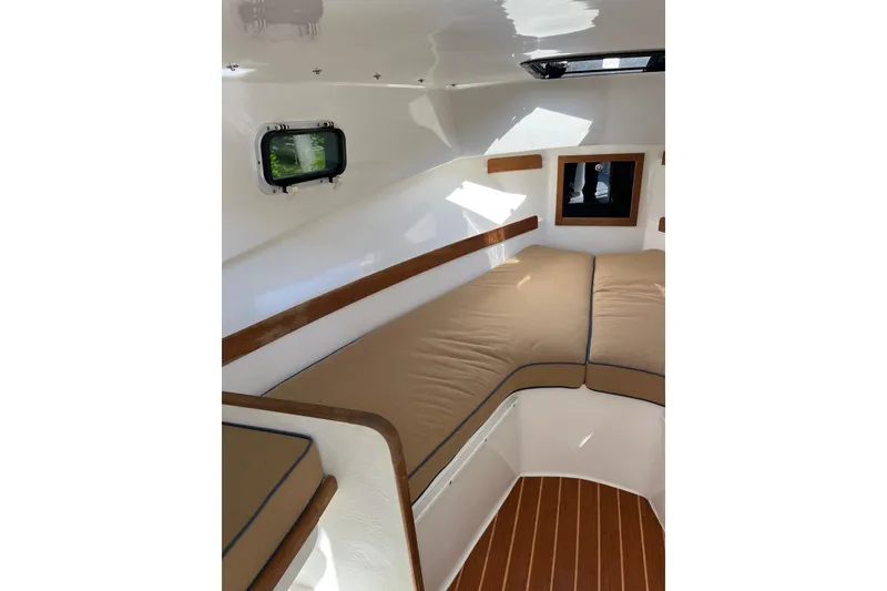Slide: The Image of Interior cabin of 2014 Seaway 24 Seafarer boat with cushioned seating and wooden accents. - 3