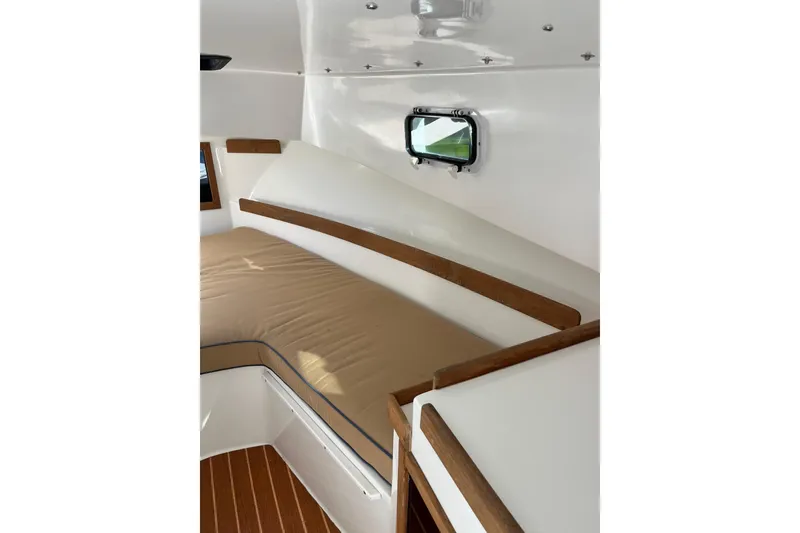 Slide: The Image of Interior cabin of 2014 Seaway 24 Seafarer with cushioned seating and wooden accents. - 4