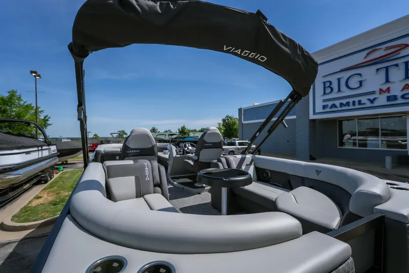 Slide: The Image of 2026 Viaggio Z24U pontoon boat with gray seating, displayed at a boat dealership. - 6