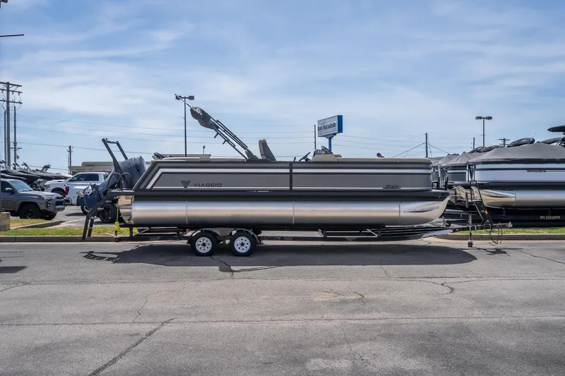 Slide: The Image of 2026 Viaggio Z24U pontoon boat on trailer in parking lot under clear sky. - 21