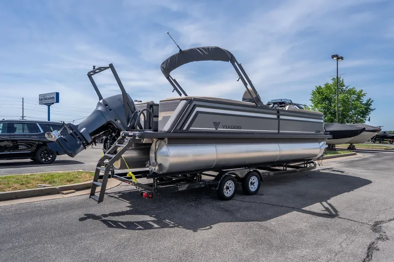 Slide: The Image of 2026 Viaggio Z24U pontoon boat on trailer in parking lot, under clear sky. - 22