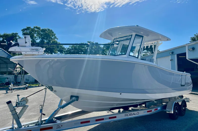 Slide: The Image of 2026 Robalo R270 Center Console boat on trailer under clear blue sky. - 2