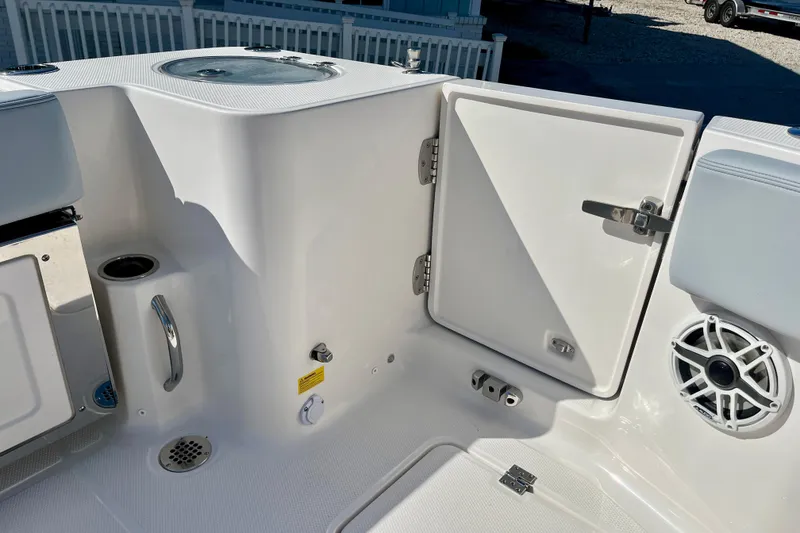 Slide: The Image of 2026 Robalo R270 Center Console boat interior with open storage compartment and speaker. - 22