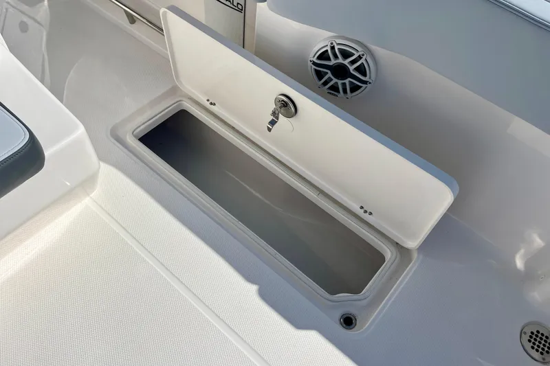 Slide: The Image of 2026 Robalo R270 Center Console boat storage compartment with open lid and speaker. - 24